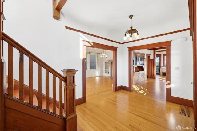 interior space featuring light wood-type flooring, a notable chandelier, visible vents, and stairs