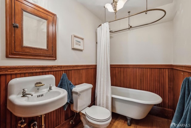 4020 20th St, San Francisco, CA 94114 - bathroom featuring a freestanding tub, wainscoting, toilet, wood finished floors, and a sink