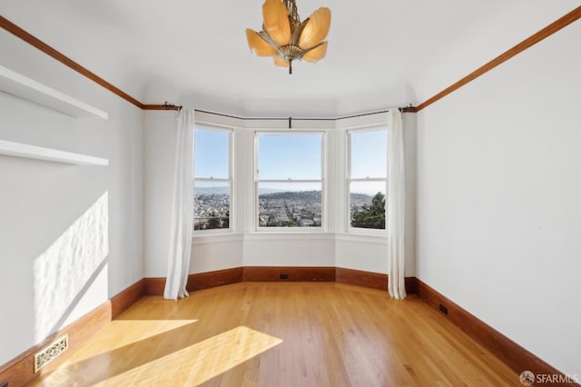 spare room with wood finished floors and baseboards