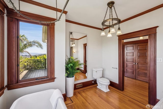 4020 20th St, San Francisco, CA 94114 - bathroom featuring a freestanding bath, wood finished floors, crown molding, toilet, and baseboards