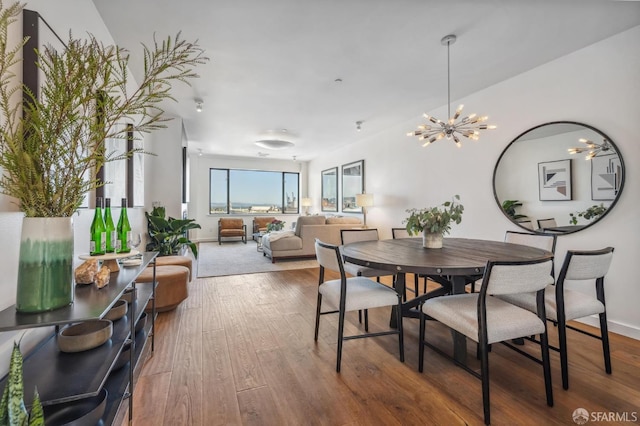 dining area featuring wood-type flooring and an inviting chandelier