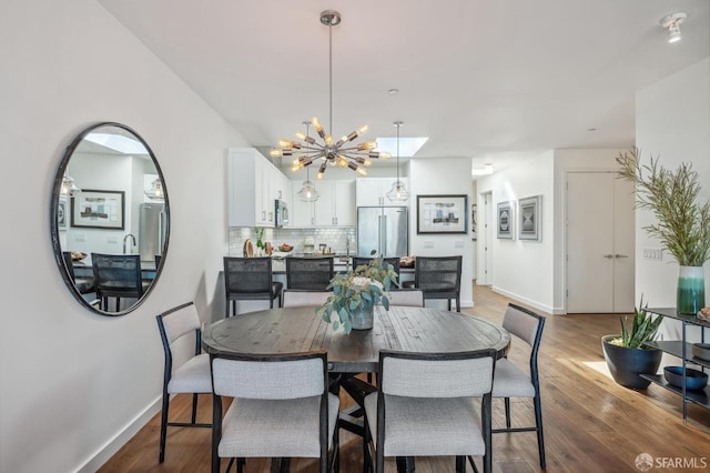 dining space with a chandelier and dark hardwood / wood-style flooring