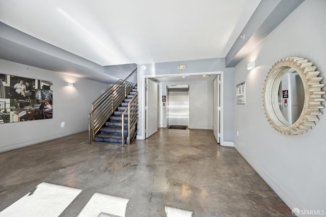 interior space with concrete flooring and elevator