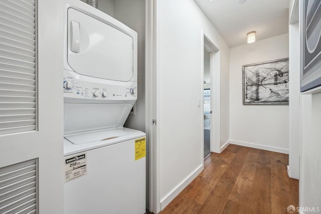 laundry room featuring stacked washer and clothes dryer and dark hardwood / wood-style floors