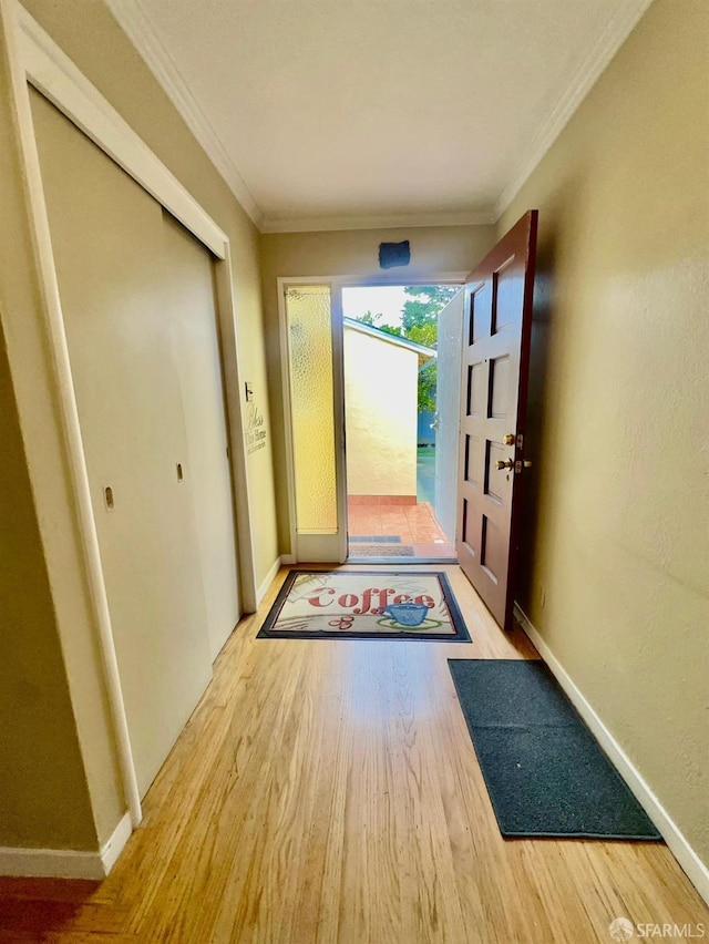 entryway with ornamental molding, baseboards, and wood finished floors