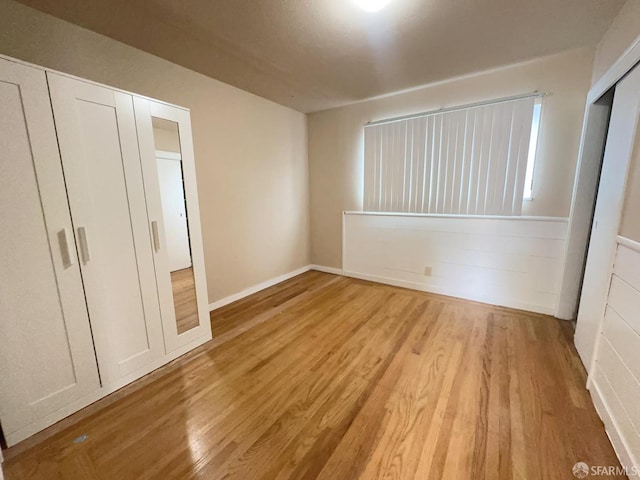 unfurnished bedroom with light wood-type flooring and baseboards