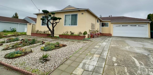 view of front of house with a garage, concrete driveway, and stucco siding