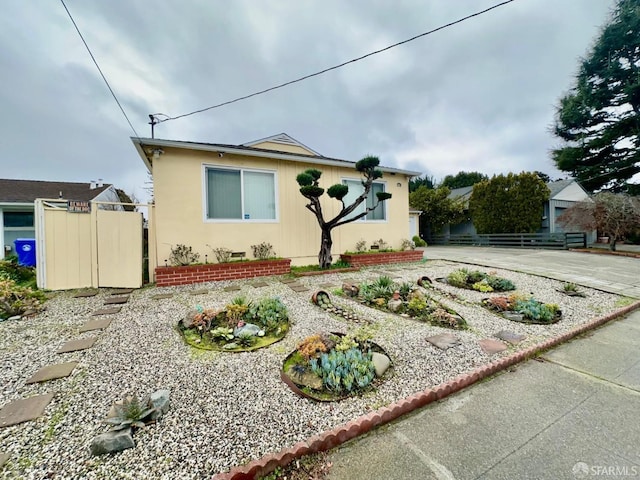 view of front of house featuring crawl space, driveway, and fence