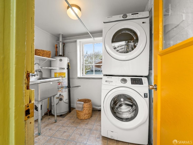 clothes washing area featuring stacked washer and dryer, laundry area, and strapped water heater