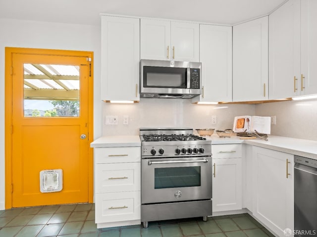 kitchen with stainless steel appliances, tasteful backsplash, light countertops, and white cabinetry