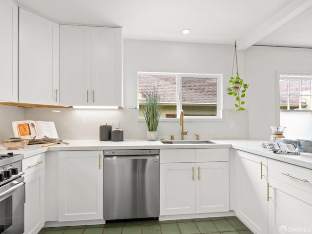 kitchen featuring recessed lighting, stainless steel appliances, a sink, white cabinets, and light countertops