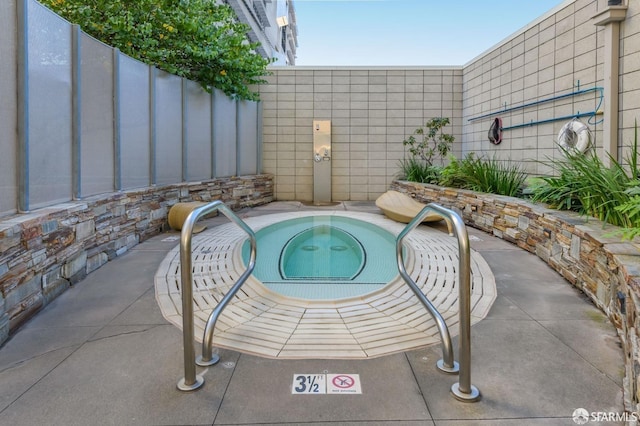 view of pool featuring an in ground hot tub