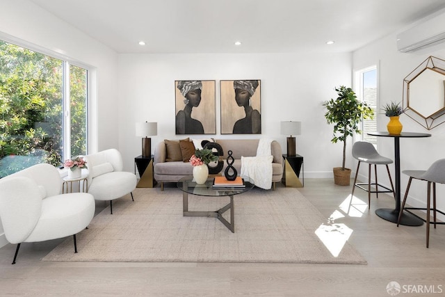 sitting room featuring recessed lighting, baseboards, light wood finished floors, and a wall mounted AC