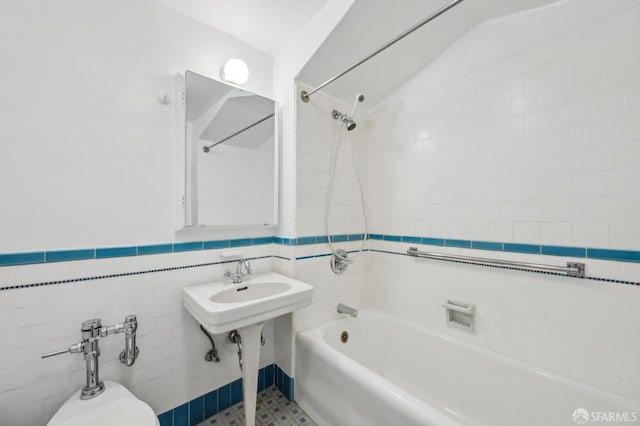 bathroom with vaulted ceiling, tile walls, and tiled shower / bath combo