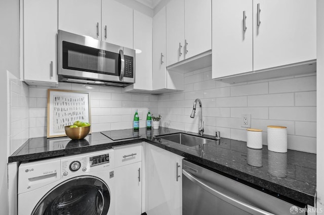 kitchen featuring appliances with stainless steel finishes, washer / dryer, and white cabinets