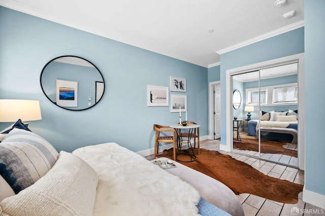 tiled bedroom with ornamental molding and a closet