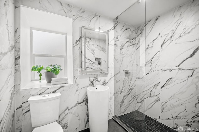 bathroom with a tile shower and toilet