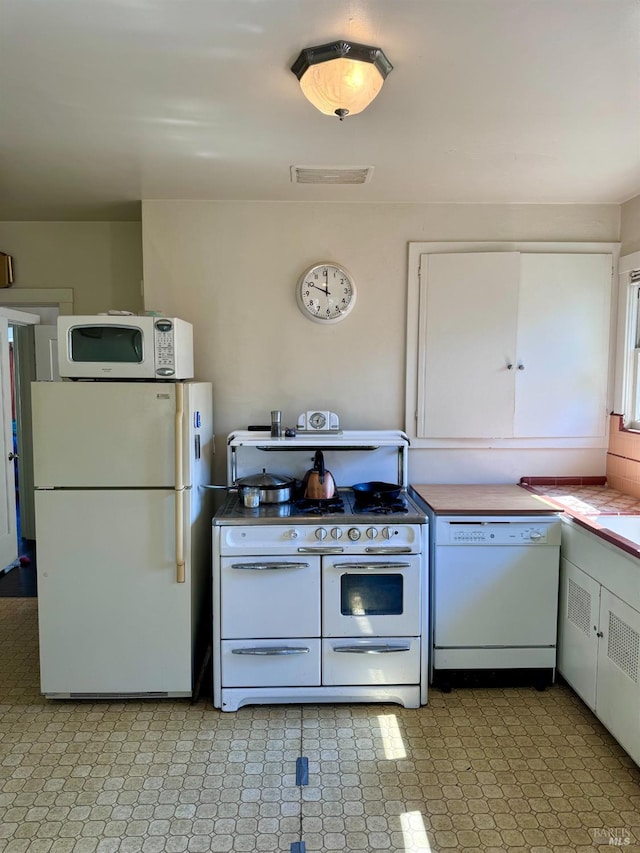 kitchen with white cabinets and white appliances