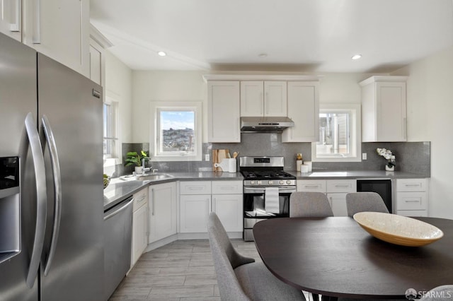 kitchen with backsplash, appliances with stainless steel finishes, and white cabinetry