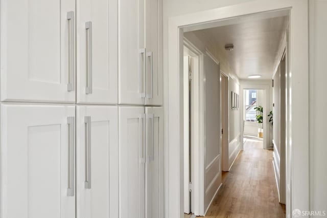 corridor with light hardwood / wood-style floors