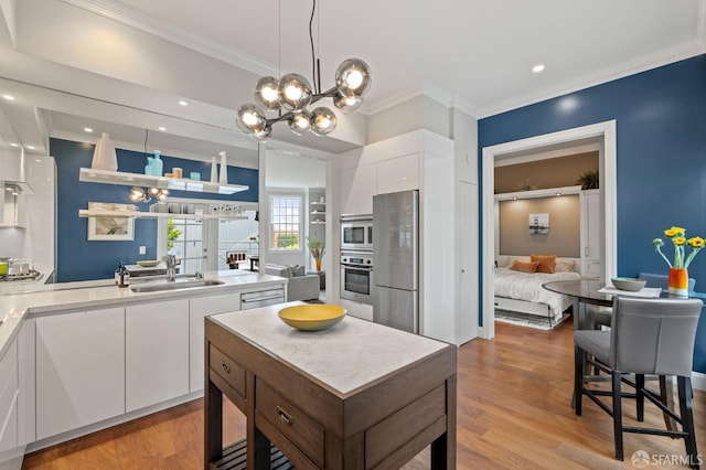 116 Alta St, San Francisco, CA 94133 - kitchen featuring stainless steel appliances, a chandelier, modern cabinets, ornamental molding, and white cabinetry