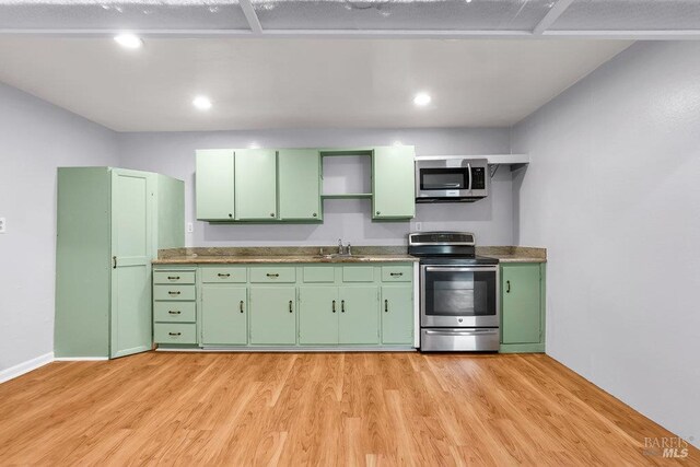 1685 Bay Flat Rd, Bodega Bay, CA 94923 - kitchen with appliances with stainless steel finishes, green cabinetry, a sink, light wood-style floors, and recessed lighting