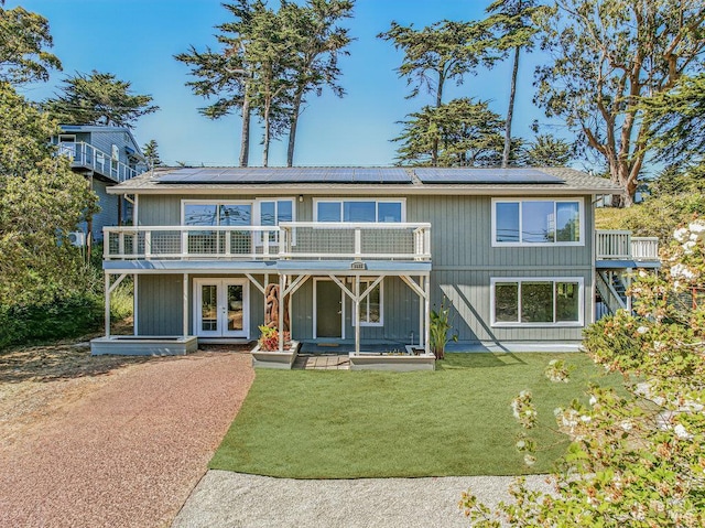1685 Bay Flat Rd, Bodega Bay, CA 94923 - view of front of property featuring french doors, solar panels, and a front lawn