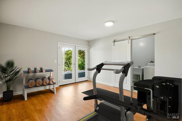1685 Bay Flat Rd, Bodega Bay, CA 94923 - exercise area with french doors, a barn door, wood finished floors, and baseboards