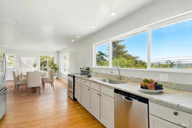 1685 Bay Flat Rd, Bodega Bay, CA 94923 - kitchen with stainless steel appliances, a sink, recessed lighting, light wood-style floors, and white cabinets