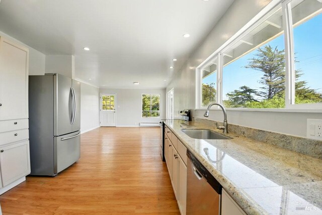 1685 Bay Flat Rd, Bodega Bay, CA 94923 - kitchen with stainless steel appliances, a sink, light wood-style flooring, recessed lighting, and white cabinetry