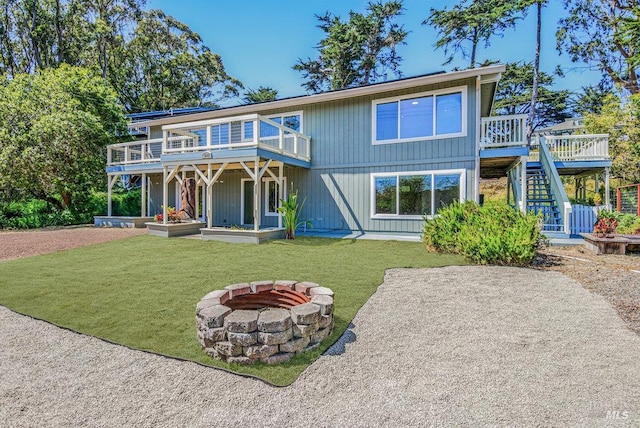 1685 Bay Flat Rd, Bodega Bay, CA 94923 - view of front facade featuring stairs, a fire pit, a deck, and a front yard