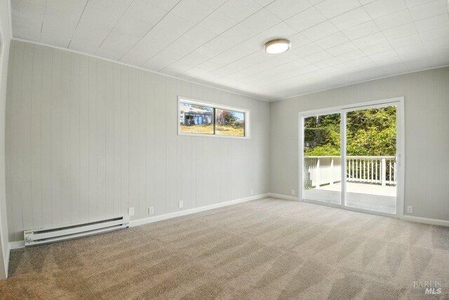 1685 Bay Flat Rd, Bodega Bay, CA 94923 - spare room with baseboard heating, carpet, wood walls, and baseboards