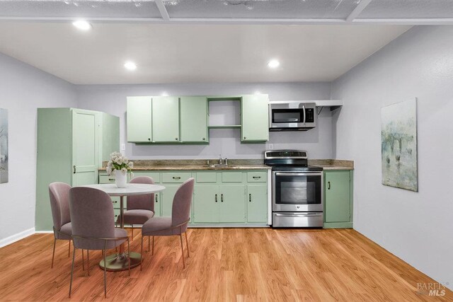 1685 Bay Flat Rd, Bodega Bay, CA 94923 - kitchen featuring green cabinetry, appliances with stainless steel finishes, a sink, and light wood finished floors