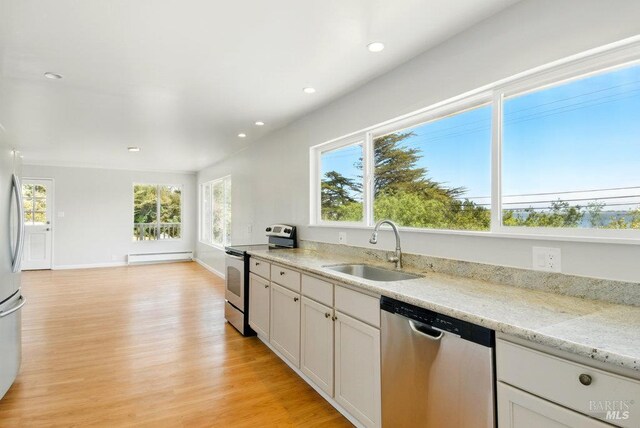 1685 Bay Flat Rd, Bodega Bay, CA 94923 - kitchen with stainless steel appliances, a sink, a baseboard heating unit, recessed lighting, and light wood-style floors