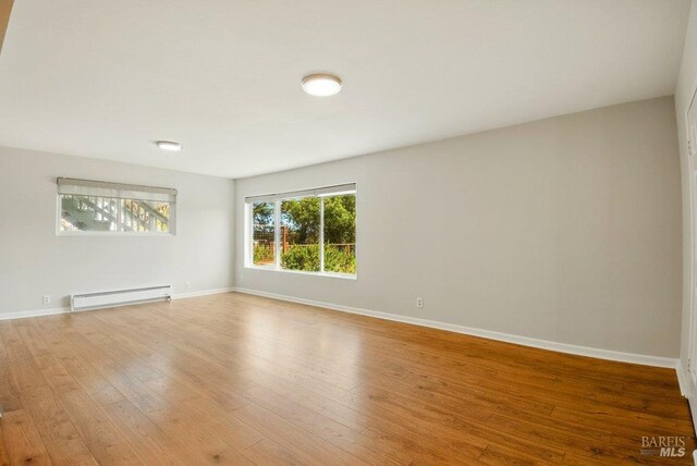 1685 Bay Flat Rd, Bodega Bay, CA 94923 - unfurnished room with baseboard heating, wood finished floors, and baseboards