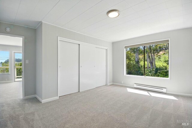 1685 Bay Flat Rd, Bodega Bay, CA 94923 - unfurnished bedroom with baseboard heating, carpet, multiple windows, ornamental molding, and a closet