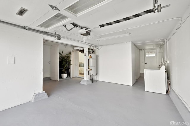 garage featuring strapped water heater, a garage door opener, and visible vents