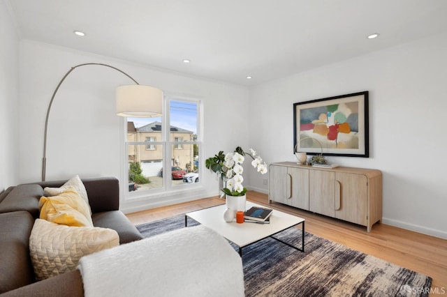 living room featuring recessed lighting, baseboards, and light wood finished floors