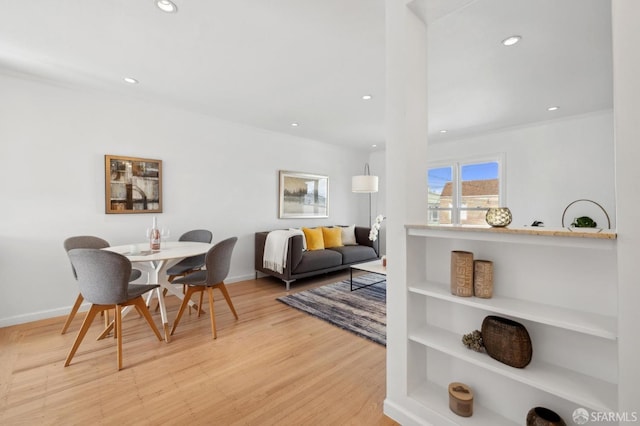 dining room with recessed lighting, baseboards, light wood-style flooring, and crown molding