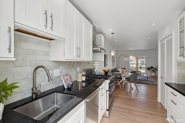 kitchen featuring a sink, appliances with stainless steel finishes, white cabinets, and light wood finished floors