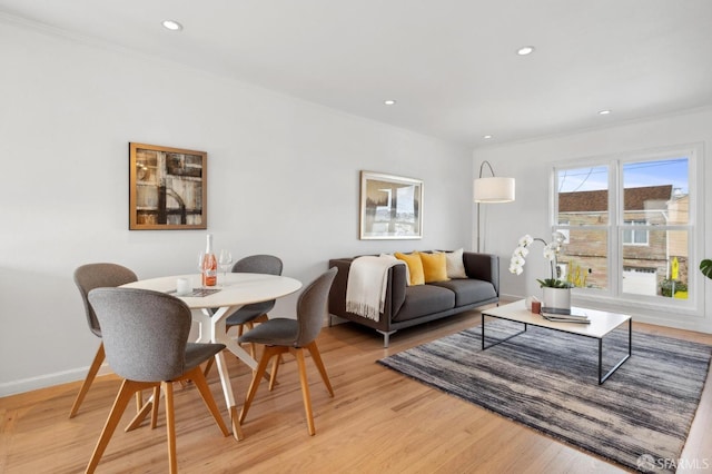 dining space with crown molding, light wood-style flooring, recessed lighting, and baseboards