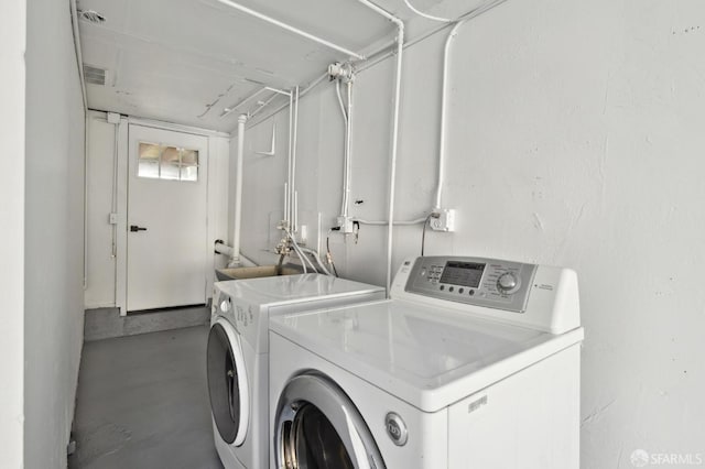 laundry area with washer and dryer and a sink