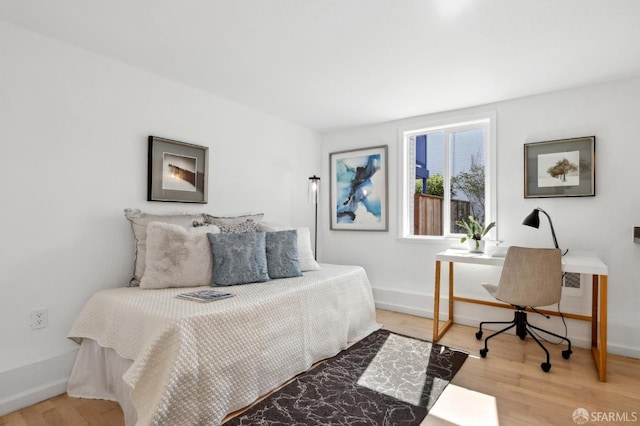 bedroom with baseboards and light wood-style floors