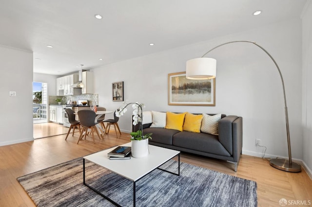 living room featuring recessed lighting, light wood-type flooring, and baseboards