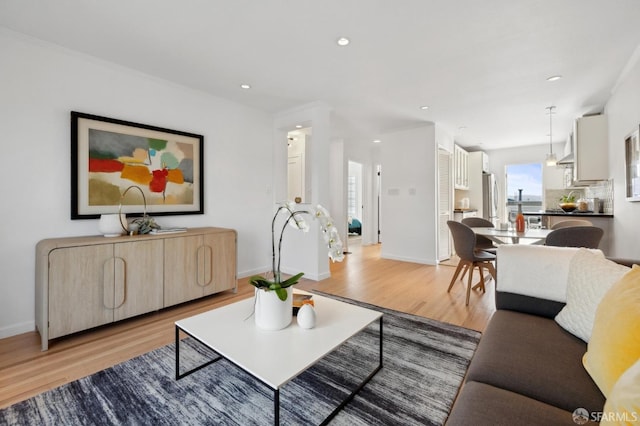 living area with recessed lighting, light wood-style floors, and baseboards