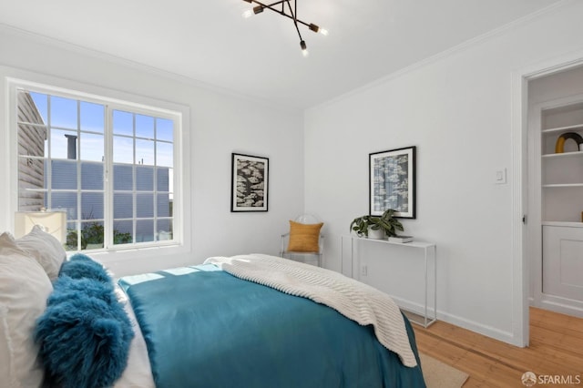 bedroom featuring light wood-style flooring, baseboards, and ornamental molding