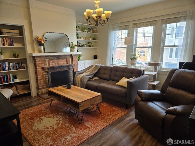 living area with dark wood-style flooring, an inviting chandelier, a wealth of natural light, and a fireplace