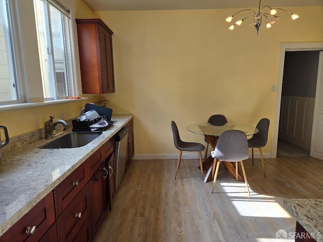 kitchen featuring light wood-type flooring, a sink, plenty of natural light, and stainless steel dishwasher