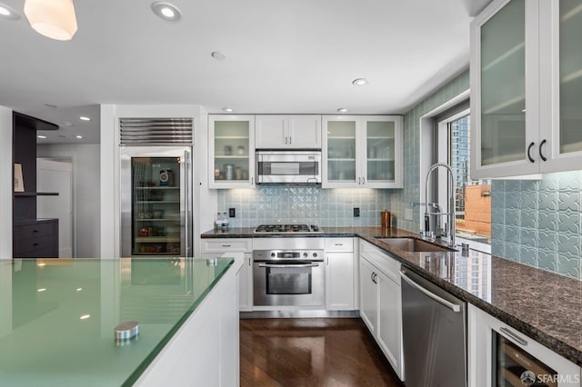 333 1st St Unit N1404, San Francisco, CA 94105 - kitchen featuring stainless steel appliances, a sink, backsplash, white cabinets, and dark stone countertops