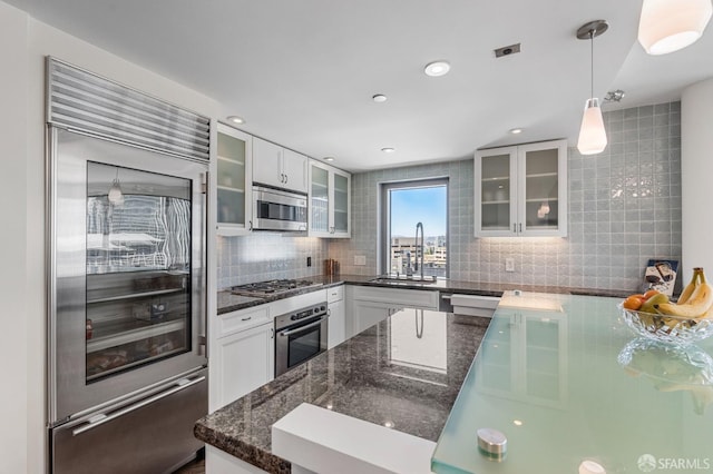 333 1st St Unit N1404, San Francisco, CA 94105 - kitchen with stainless steel appliances, a sink, backsplash, white cabinets, and decorative light fixtures